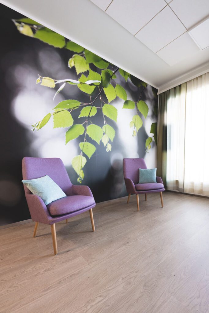 Nojatuolit kuvatapetin edessä.